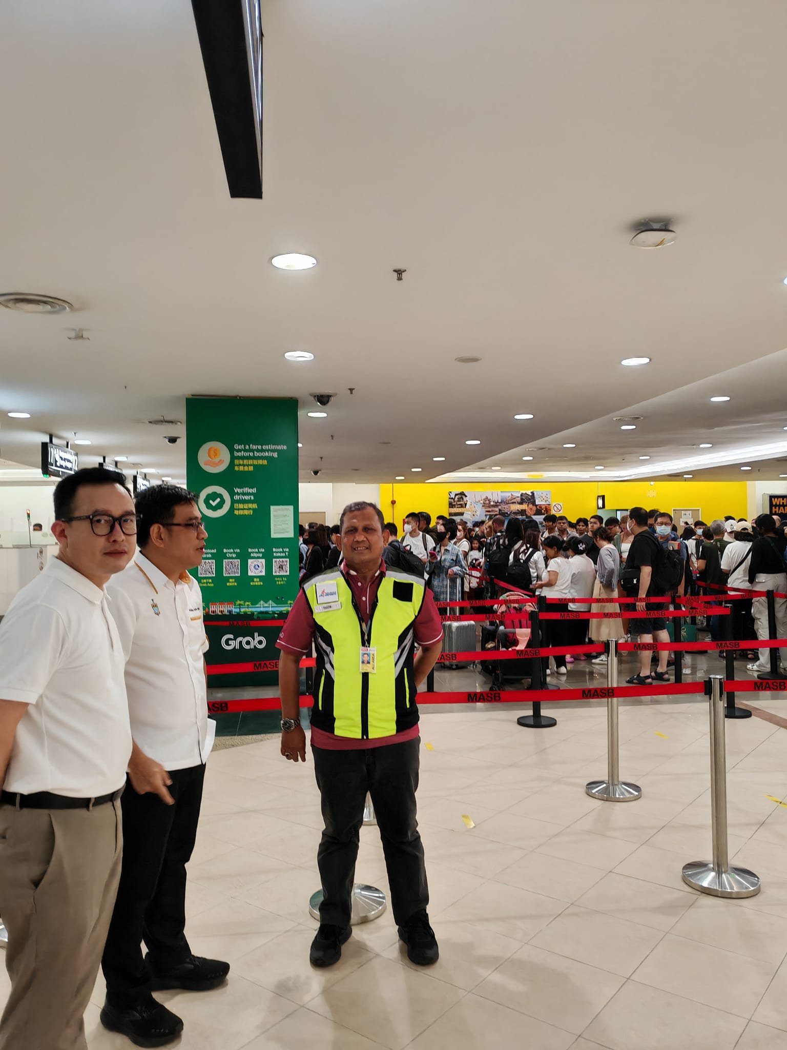 黄汉伟（左2）在黄茁原（左）陪同下，巡视槟城机场入境处的情况。